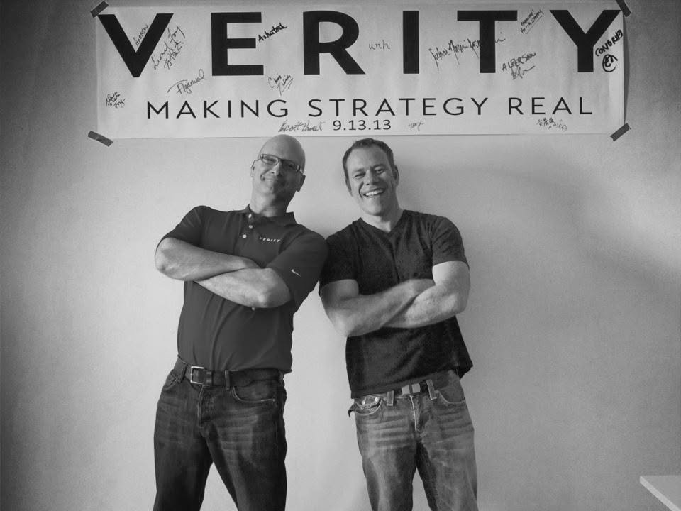 Andrew Cukurs and Chris Tabish under a signed banner reading Verity, Making strategy real, 9.13.13